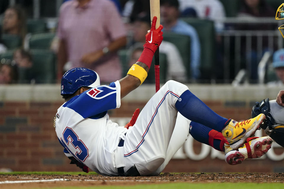 Atlanta Braves' Ronald Acuna Jr. falls to the ground after connecting on a home run in the fourth inning of a baseball game against the Milwaukee Brewers, Friday, May 6, 2022, in Atlanta. (AP Photo/John Bazemore)