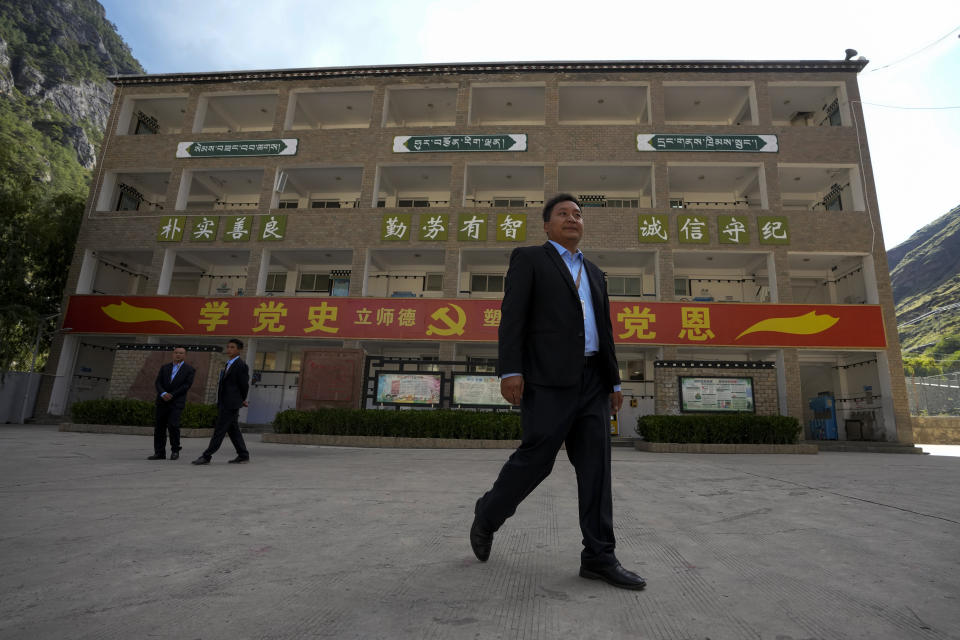 Officials walk at the compound of the Shangri-La Key Boarding School during a media-organized tour in Dabpa county, Kardze Prefecture, Sichuan province, China on Sept. 5, 2023. Village schools have been shuttered across China's Tibet and replaced with centralized boarding schools that critics say represents forced assimilation. Activists estimate 1 million Tibetan children study at such boarding schools. (AP Photo/Andy Wong)