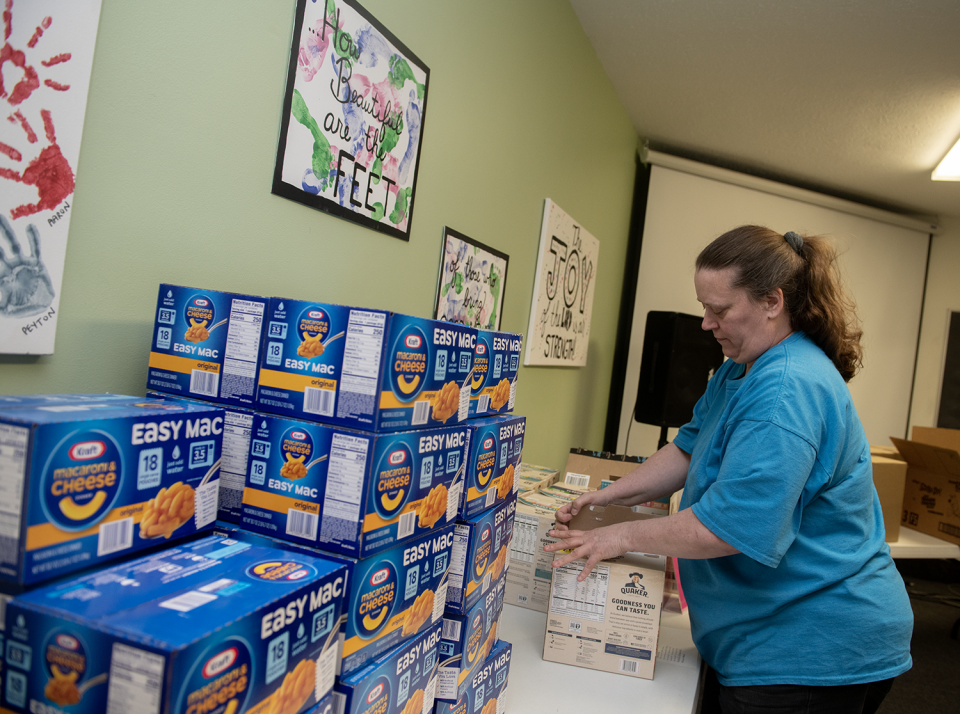 Carla Prichard unpacks macaroni and cheese during a Raven Packs volunteer event April 27 at Portage Community Chapel in Ravenna.