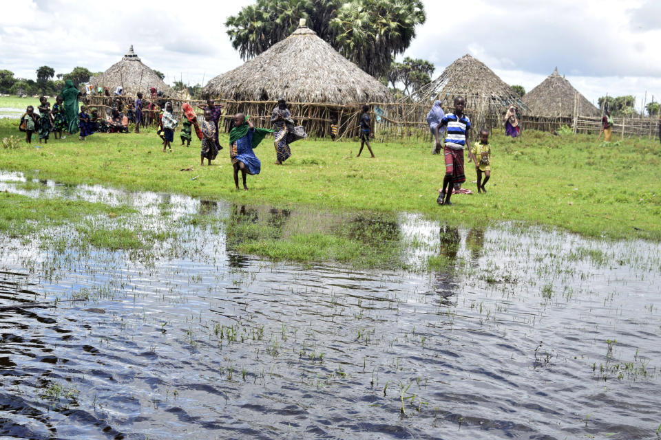 Residents are seen in the flooded village of Lumshi in Mpeketoni within Lamu County, Kenya, Friday Nov. 17 2023. Unrelenting rainfall across Kenya's northern counties and the capital, Nairobi, has led to widespread flooding, displacing an estimated 36,000 people and killing 46 people since the beginning of the rainy season less than a month ago.(AP Photo/Gideon Maundu).