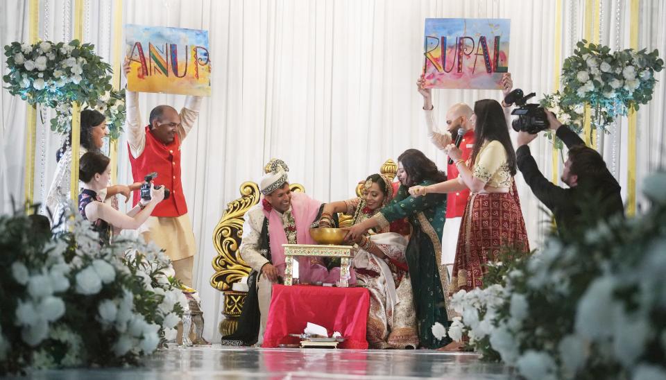 As family and friends cheer them on during the main wedding ceremony on the morning of June 10, Anup Kumar Kanodia and Rupal Ramesh Shah play Koda Kodi, a game where they fish a ring from a large pot. The belief is the person who finds the ring will "rule the household."