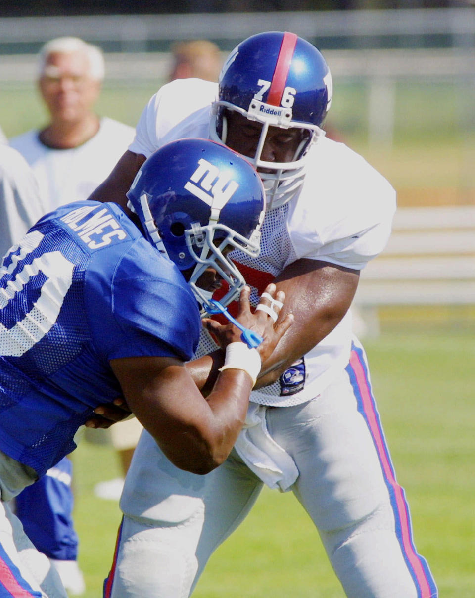 File-This July 31, 2001 file photo shows New York Giants tackle Lomas Brown, right, working against defensive end Kenny Holmes during training camp in Albany, N.Y. Brown is one of four former players who have filed the latest lawsuit claiming the NFL didn't properly protect its players from concussions, citing the bounties paid to New Orleans Saints players for hard hits as just the most recent evidence of the league's violent culture. (AP Photo/Dave Oxford, File)