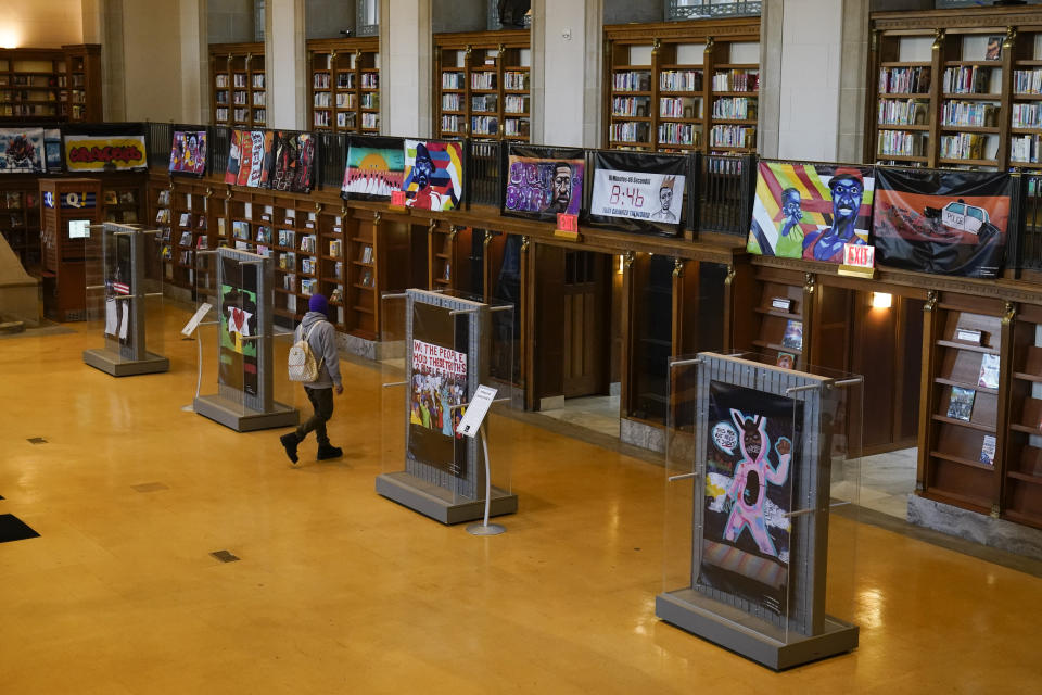 Vinyl banners representing the 24 murals that were painted in the downtown area of Indianapolis are displayed at the Central Library, Thursday, Dec. 10, 2020. During protests after George Floyd’s death, the streets of countless major cities became temporary galleries of artwork conveying collective pain and anger. But as these ephemeral artworks began to come down or be wiped from walls, patchworks of artists and activists rushed to preserve them. (AP Photo/Darron Cummings)