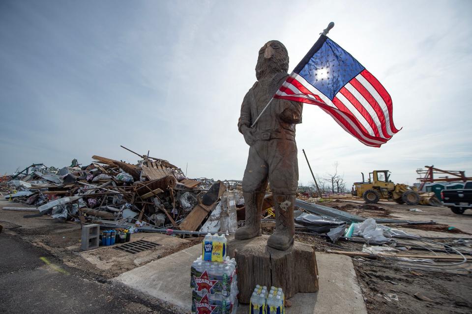 U.S. flags, with a backdrop of storm debris, dot the landscape in Rolling Fork on Tuesday. The small Delta town, fighting to recover, was slammed by an F-4 tornado Friday night.