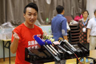 Pro-democracy candidate Jimmy Sham, left, speaks to reporters after winning his election in Hong Kong, early Monday, Nov. 25, 2019. Vote counting was underway in Hong Kong on Sunday after a massive turnout in district council elections seen as a barometer of public support for pro-democracy protests that have rocked the semi-autonomous Chinese territory for more than five months. (AP Photo/Vincent Thian)