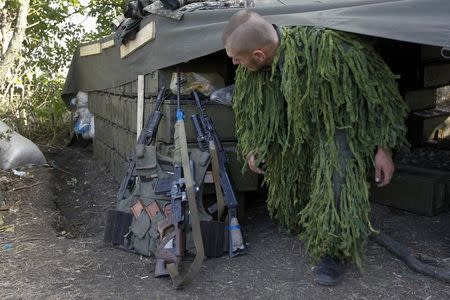 A Ukrainian sniper leaves his shelter at a military camp in Luhansk region August 21, 2014. REUTERS/Valentyn Ogirenko