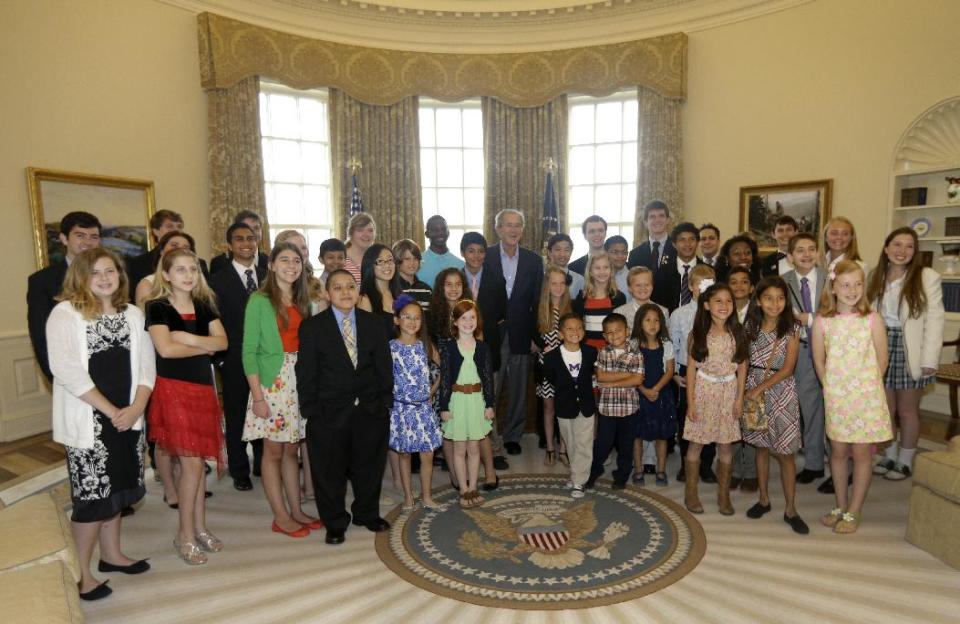 Former President George W. Bush, center, poses with 43 students from Dallas-Fort Worth Schools who were the first 43 official guest to tour the Bush Presidential Library on its' opening day, Wednesday, May 1, 2013, in Dallas. (AP Photo/Tony Gutierrez)