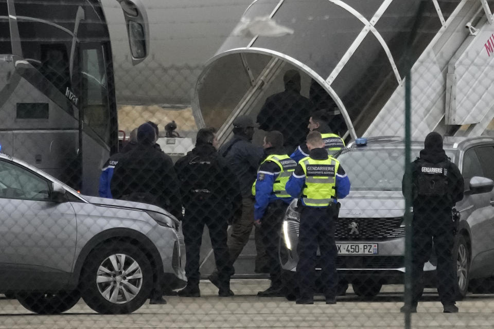 Men board the plane grounded by police at the Vatry airport , Monday, Dec. 25, 2023 in Vatry, eastern France. A charter plane grounded in France for a human trafficking investigation is scheduled to leave Monday for India, after an exceptional holiday ordeal that left some 300 Indians en route for Central America blocked inside a rural French airport for four days. (AP Photo/Christophe Ena)