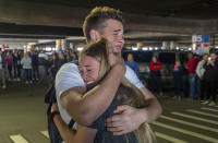 In this Sunday, March 22, 2020 photo, Hope Preston welcomes home her brother Elder Kaleb Preston from his mission in the Philippines, at the Salt Lake City International Airport. Sen. Mitt Romney and Utah state leaders are criticizing a large gathering of family and friends who went to the Salt Lake City airport to welcome home missionaries when people are supposed to be keeping their distance from one another to prevent more spread of the coronavirus. (Rick Egan/The Salt Lake Tribune via AP)