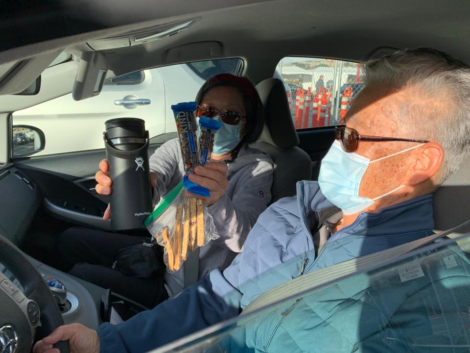 Inja Kim, 72, shows the snacks she brought in expectation of a long wait to get the COVID-19 vaccine for her husband Kwang Kim seated next to her. The couple made it through San Francisco's mass vaccination clinic on January 22, 2021 in just 25 minutes.