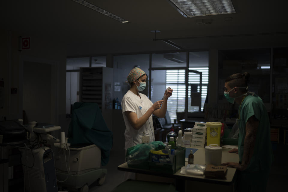 Una trabajadora de salud prepara medicamento para un paciente enfermo de COVID-19 en una de las unidades de cuidados intensivos en el hospital Germans Trias i Pujol en Badalona, Barcelona, España, el miércoles 1 de abril de 2020. (AP Foto/Felipe Dana)