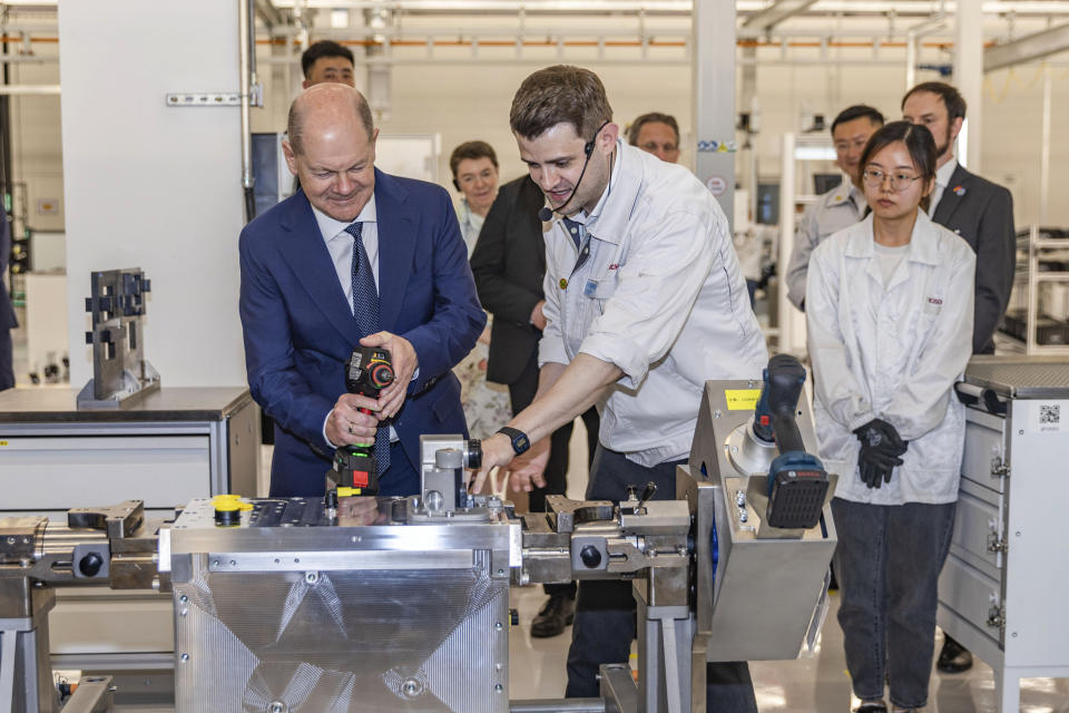 In this photo released by Xinhua News Agency, German Chancellor Olaf Scholz visits Bosch Hydrogen Powertrain Systems (Chongqing) Co., Ltd. in Jiulongpo District of southwest China's Chongqing Municipality on Sunday, April 14, 2024. German Chancellor Olaf Scholz has arrived in China on a visit focused on the increasingly tense economic relationship between the sides and differences over Russia's invasion of Ukraine. (Huang Wei/Xinhua via AP)