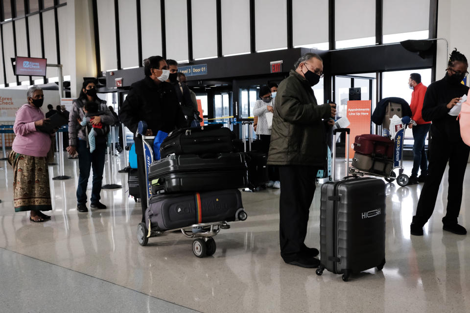Travelers arrive for flights at Newark Liberty International Airport on Nov. 30, 2021, in Newark, N.J.