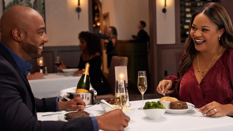 Couple eating steak dinner at restaurant