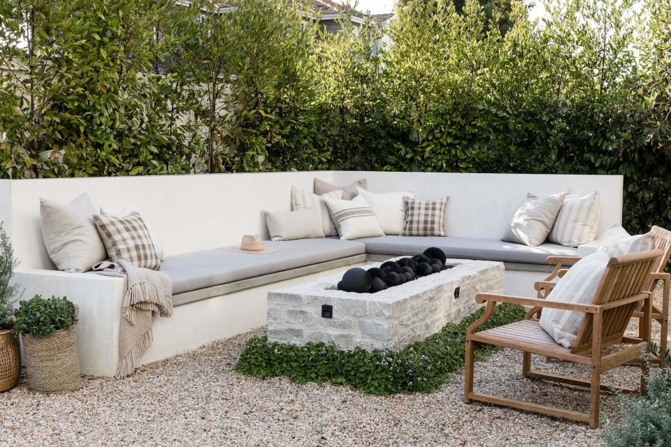 a large cream corner bench on a patio with a firepit