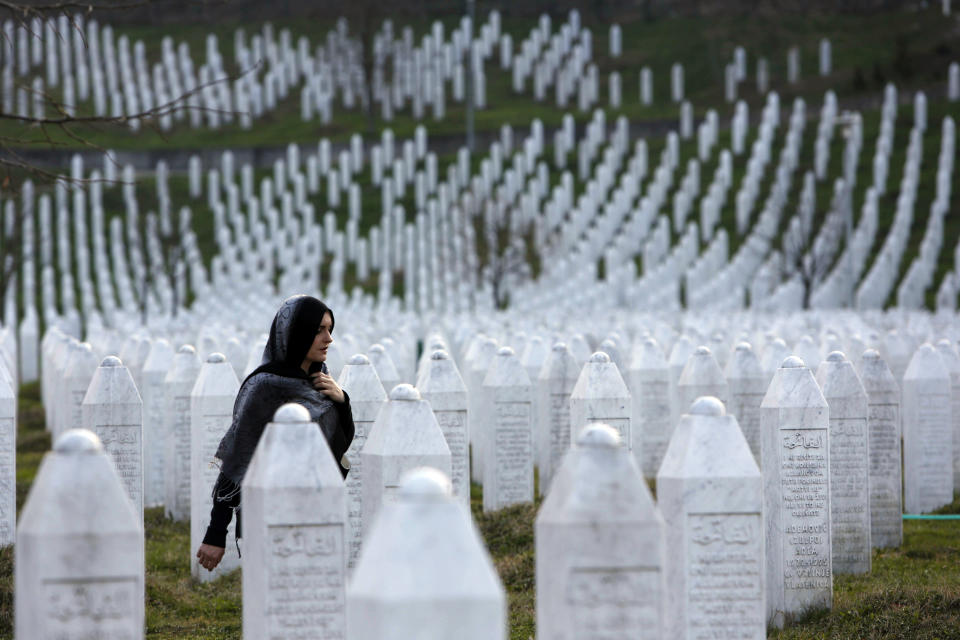 FILE - In this Sunday, March 20, 2016 file photo, a Bosnian woman walks among gravestones at Memorial Centre Potocari near Srebrenica, Bosnia and Herzegovina. Nearly a quarter of a century since Bosnia’s devastating war ended, former Bosnian Serb leader Radovan Karadzic is set to hear the final judgment on whether he can be held criminally responsible for unleashing a wave of murder and destruction during Europe’s bloodiest carnage since World War II. United Nations appeals judges on Wednesday March 20, 2019, will decide whether to uphold or overturn Karadzic’s 2016 convictions for genocide, crimes against humanity and war crimes and his 40-year sentence. (AP Photo/Amel Emric, File)