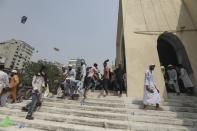 People throw footwear during a protest against the visit of Indian Prime Minister Narendra Modi, after Friday prayers at Baitul Mokarram mosque in Dhaka, Bangladesh, Friday, March 26, 2021. Witnesses said violent clashes broke out after one faction of protesters began waving their shoes as a sign of disrespect to Indian Prime Minister Narendra Modi, and another group tried to stop them. Local media said the protesters who tried to stop the shoe-waving are aligned with the ruling Awami League party. The party criticized the other protest faction for attempting to create chaos in the country during Modi’s visit. (AP Photo/Mahmud Hossain Opu)