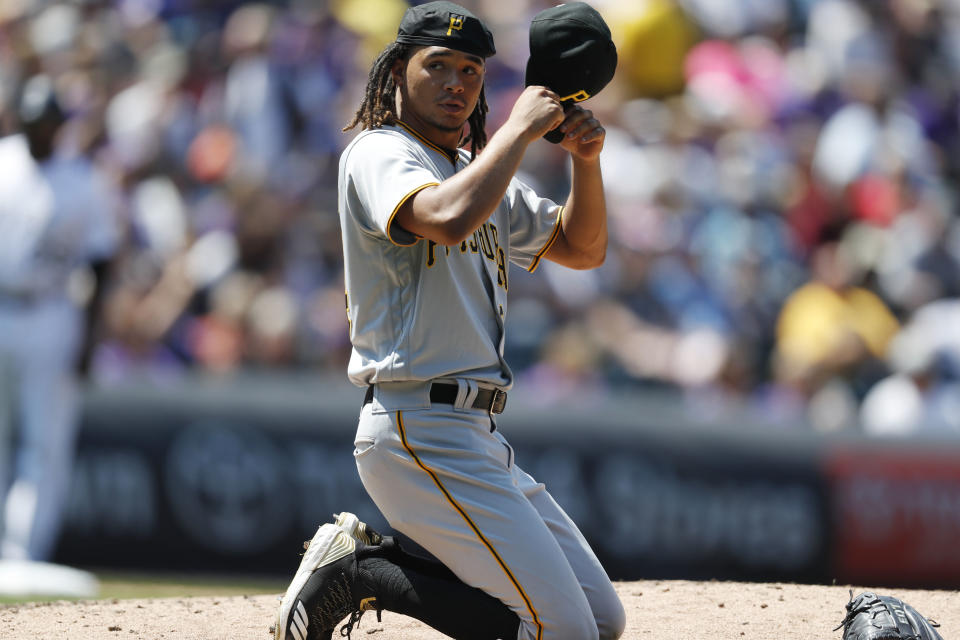Pittsburgh Pirates starting pitcher Chris Archer puts on his cap after losing his balance while trying to field a single hit up the box by Colorado Rockies' DJ LeMahieu in the fourth inning of a baseball game Wednesday, Aug. 8, 2018, in Denver. (AP Photo/David Zalubowski)