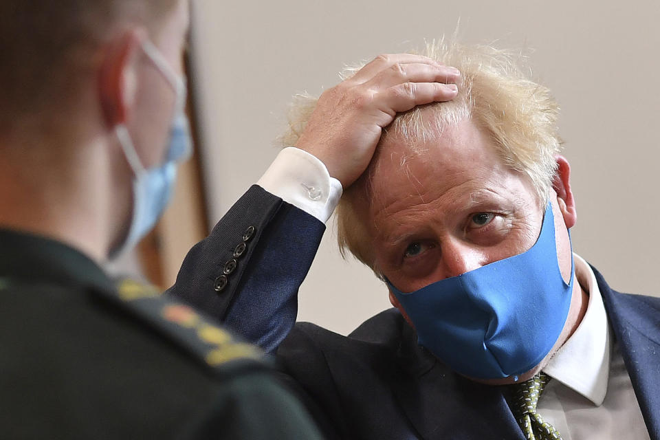 Britain's Prime Minister Boris Johnson, wearing a face mask, talks with a paramedic during a visit to the headquarters of the London Ambulance Service NHS Trust in London, Monday July 13, 2020. (Ben Stansall/Pool via AP)