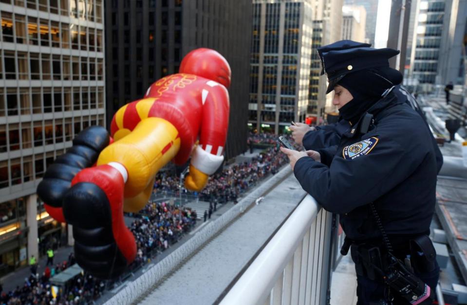 New York City Police Department officers watch the Ronald McDonald balloon (Reuters)