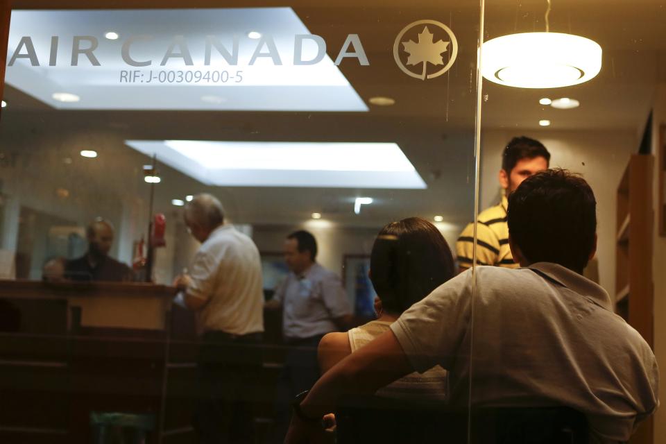 Customers wait their turn to be served at the Air Canada's office in Caracas