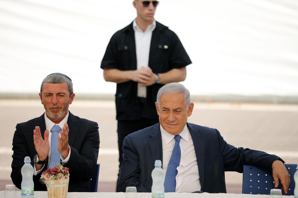 Israeli Prime Minister Benjamin Netanyahu, right, sits next to Education Minister Rafi Peretz during a ceremony opening the school year in the settlement of Elkana Sunday, Sept. 1, 2019. Netanyahu is reaffirming his pledge to impose Israeli sovereignty on West Bank settlements. (Amir Cohen/Pool Photo via AP)