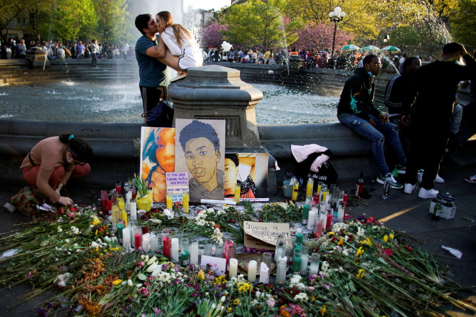 A woman places a candle at a makeshift memorial with the image of Daunte Wright after the verdict in the trial of former Minneapolis police officer Derek Chauvin, found guilty of the death of George Floyd, in New York City, New York, U.S., April 20, 2021. REUTERS/Eduardo Munoz     TPX IMAGES OF THE DAY