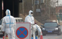 FILE PHOTO: Workers in protective suits are seen at a checkpoint on a road leading to a village near a farm where African swine fever was detected, in Fangshan district of Beijing