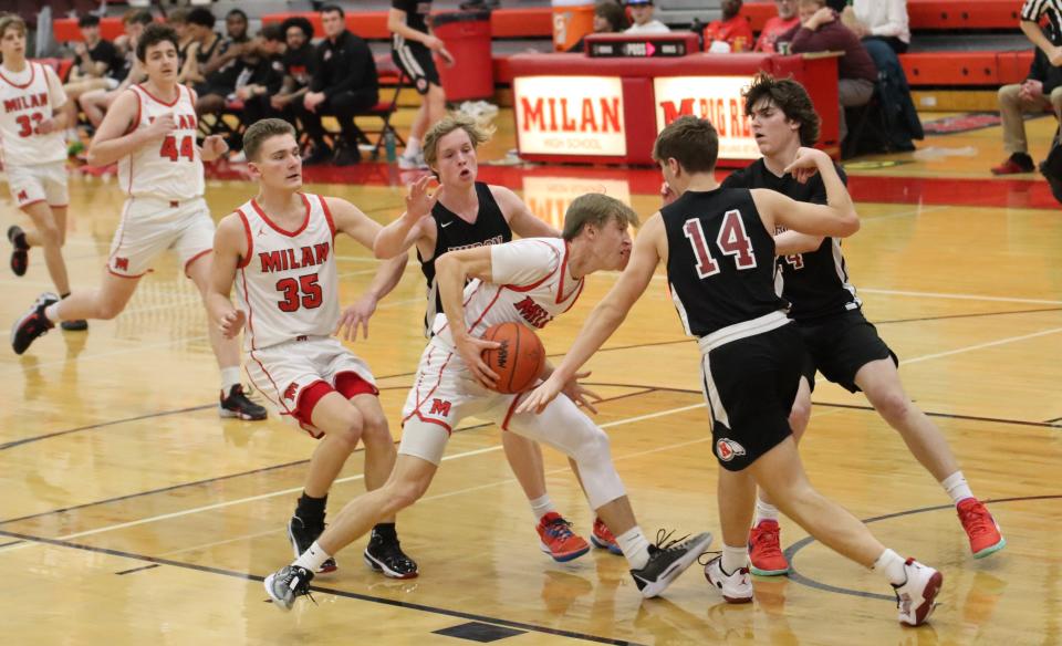 Jackson Raasch of Milan is challenged by New Boston Huron defender Marcos Balasz (14) during a 61-27 Huron win on Tuesday, Jan. 30, 2024.