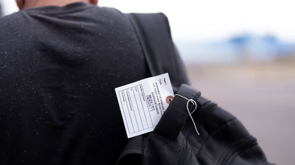 A migrant seeking asylum carries a backpack with a tag as he looks for transportation options after being processed and released, Tuesday, June 4, in San Diego.  - Gregory Bull/AP