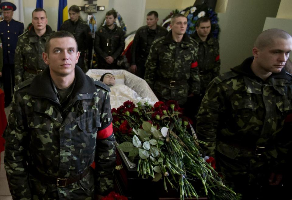 Ukrainian soldiers stand around the coffin of Sergey Kokurin, 35, during his funeral in Simferopol, Crimea, Saturday, March 22, 2014. A few hundred mourners gathered to pay their last respects to two men who were shot dead earlier in the week. Ukrainian soldier Sergey Kokurin, 35 and Russian Cossack militiaman Ruslan Kazakov, 34, are the only known victims of what has otherwise been a bloodless takeover of Crimea by Russia. (AP Photo/Vadim Ghirda)