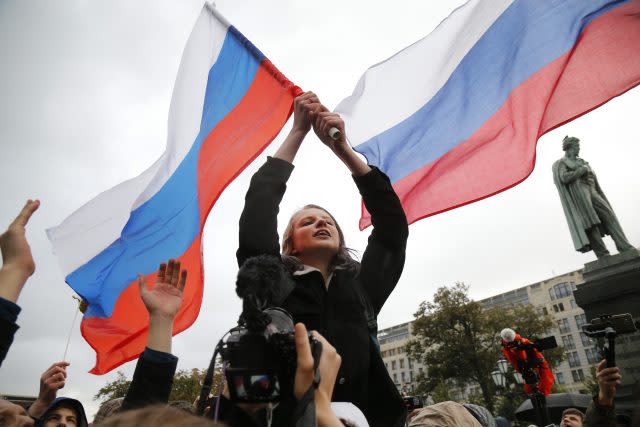 Demonstrators wave Russian flags during a rally in Moscow