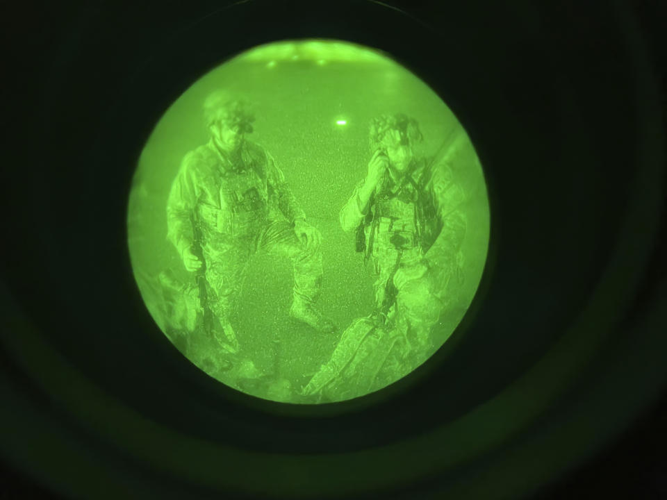 In this image made through a night vision scope and provided by the U.S. Army, Maj. Gen. Chris Donahue, commander of the U.S. Army 82nd Airborne Division, XVIII Airborne Corps, prepares to board a C-17 cargo plane at Hamid Karzai International Airport in Kabul, Afghanistan, Monday, Aug. 30, 2021, as the final American service member to depart Afghanistan. (Master Sgt. Alexander Burnett/U.S. Army via AP)