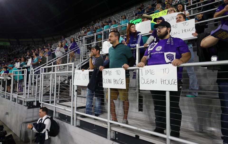 Racing Louisville FC fans held protest signs during the Louisville City FC match against Detroit City FC at the Lynn Family Stadium in Louisville, Ky. on Oct. 5, 2022.  They were supporting the players on the Racing Louisville FC team after allegations that a former coach abused players.