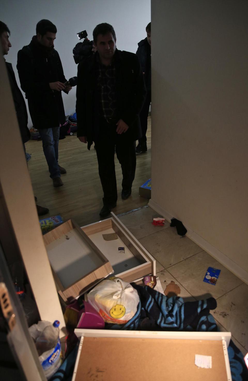 Members of the media and police stand inside the flat where a suspect of New Year's Day nightclub attack was arrested during an overnight police raid, in Istanbul, Tuesday, Jan. 17, 2017. Turkish police said they captured the gunman who carried out the deadly New Year's nightclub attack in Istanbul, with officials saying Tuesday that he's an Uzbekistan national who trained in Afghanistan and confessed to the massacre. (AP Photo/Lefteris Pitarakis)