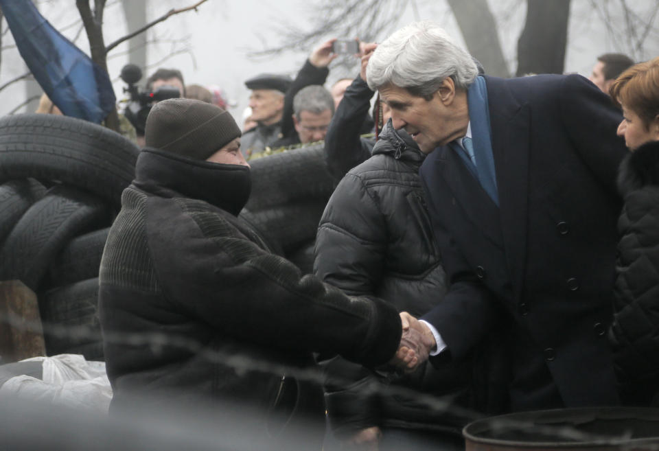 U.S. Secretary of State John Kerry, right, shakes hands with a Ukrainian protester at the barricades in Kiev, Ukraine, Tuesday, March, 4, 2014. Kerry arrived in Kiev in an expression of support for Ukraine's sovereignty, and the EU threatened a raft of punitive measures as it called an emergency summit for Thursday. (AP Photo/Efrem Lukatsky)