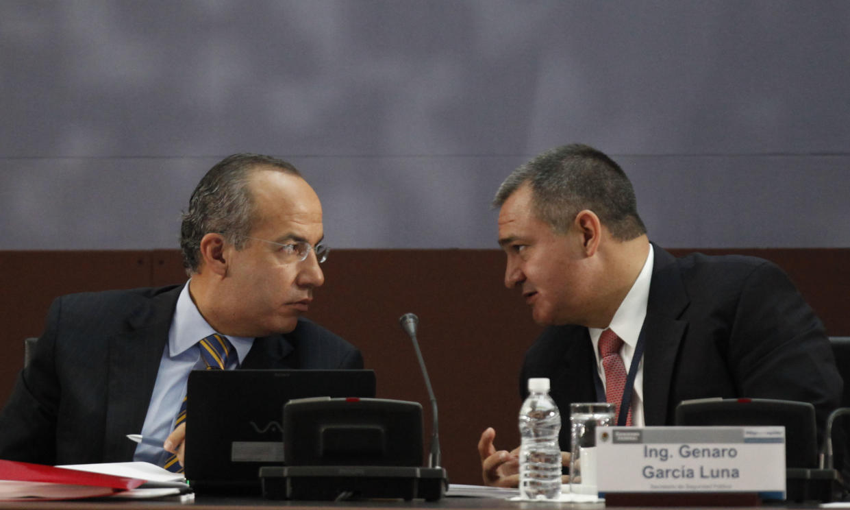 Mexico's President Felipe Calderon, left, speaks with Mexico's Secretary of Public Safety Genaro Garcia Luna at an anti-crime round-table "Dialog for Security" in Mexico City, Friday Aug. 27, 2010. (AP Photo/Alexandre Meneghini)