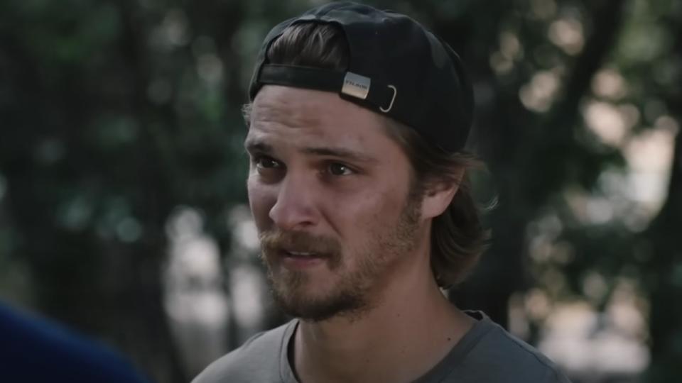 Luke Grimes wearing a backwards hat in Yellowstone.