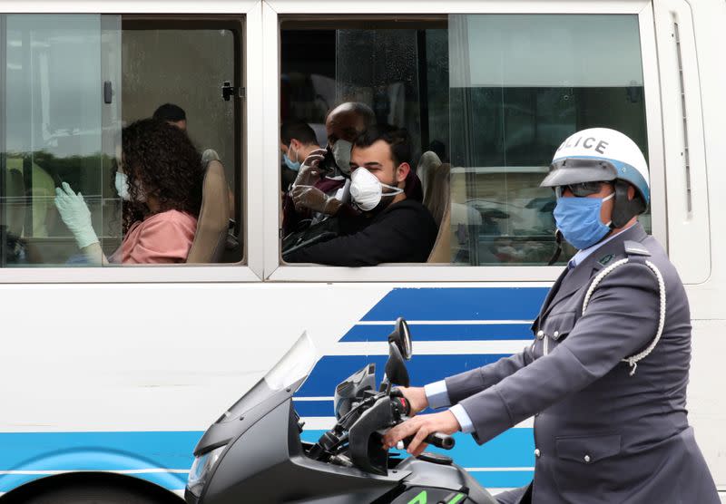 A police officer drives past a bus at Beirut's international airport