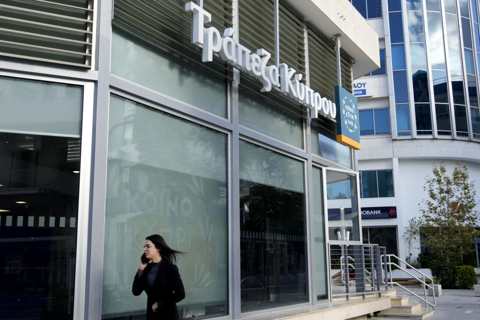 A woman walks outside of a branch of "Bank of Cyprus" in central capital Nicosia, Cyprus, Wednesday, Jan. 24, 2024. Official figures show Cyprus making significant headway in weaning itself off Russian cash and business as it tries to clean up its image as a favorite destination for Moscow's money. According to the figures, the number of Russian clients using Cypriot banks has dropped 82% between 2014 up until the end of 2022. (AP Photo/Petros Karadjias)