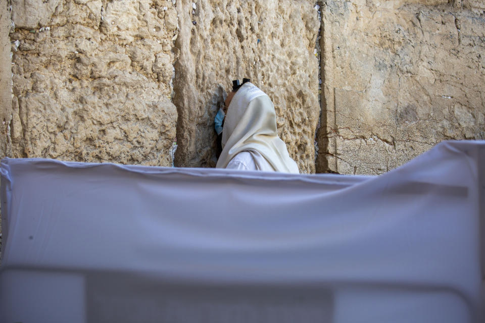 With social distancing barrier, an ultra-Orthodox Jewish man prays ahead of Yom Kippur, the holiest day in the Jewish year, at the Western Wall, in Jerusalem's Old City, Sunday, Sept. 27, 2020. For Israel's ultra-Orthodox Jews, coronavirus restrictions have raised numerous questions about how to maintain their religious lifestyle during the outbreak. A religious publisher in Jerusalem released a book in July with over 600 pages of guidance from 46 different rabbis. (AP Photo/Ariel Schalit)