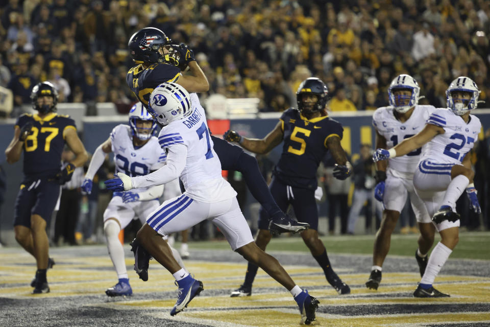 West Virginia's Preston Fox, top center, catches a touchdown over BYU's Kamden Garrett (7) during the first half of an NCAA college football game on Saturday, Nov. 4, 2023, in Morgantown, W.Va. (AP Photo/Chris Jackson)