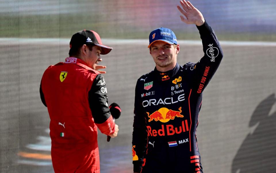 Red Bull Racing's Dutch driver Max Verstappen (R) salutes the crowd as Ferrari's Monegasque driver Charles Leclerc (L) passes by, after he took the pole position during the qualifying session ahead of the Dutch Formula One Grand Prix at the Zandvoort circuit on September 3, 2022 - AFP