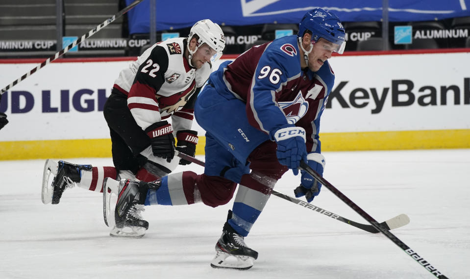 Colorado Avalanche right wing Mikko Rantanen, front, reaches out for the puck as Arizona Coyotes left wing Johan Larsson pursues in the second period of an NHL hockey game Monday, March 8, 2021, in downtown Denver. (AP Photo/David Zalubowski)