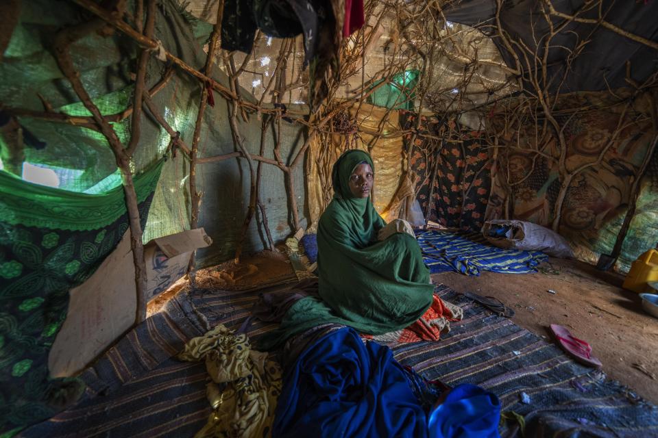 Fartum Issack sits in a shelter at a camp for displaced people on the outskirts of Dollow, Somalia, on Monday, Sept. 19, 2022. Issack and her husband carried a small body along a dusty track to a graveyard. Their 1-year-old daughter had arrived at camp sick and hungry. She was rushed for treatment, but it was too late. (AP Photo/Jerome Delay)