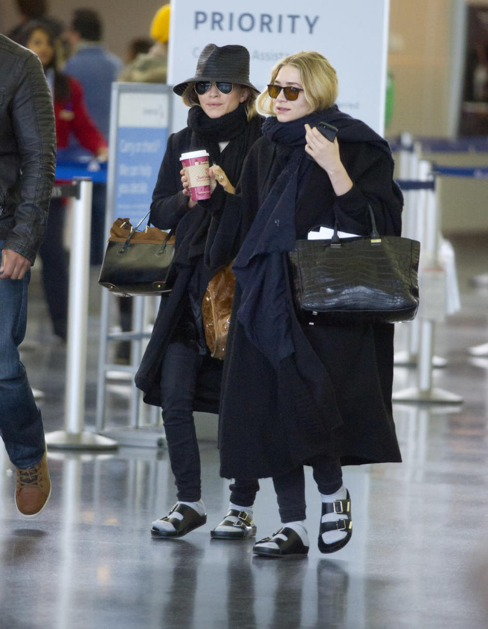 Ashley and Mary-Kate Olsen busted out all their signature looks: oversized coats, scarves, big bags, dark sunnies, Starbucks cups, and socks with sandals. They’re basically wearing Olsen twin costumes.