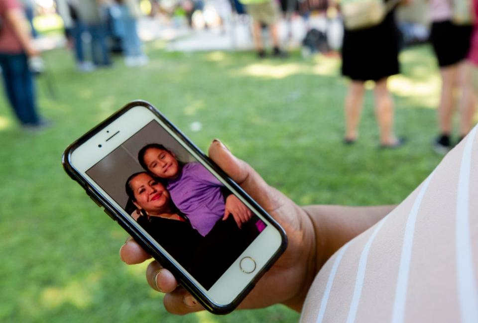 Patricia Castanon, the aunt of Annabell Rodriguez shows a photo of her niece on her phone during a prayer service at the Uvalde Town Square on May 28, 2022.