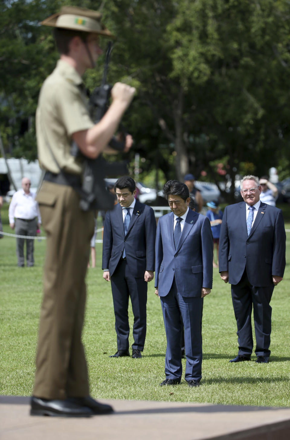 Japan's Prime Minister Shinzo Abe, second right, pauses after laying a wreath at the Cenotaph War Memorial in Darwin, Friday, Nov. 16, 2018. Abe is on a 2-day visit to Australia. (AP Photo/Rick Rycroft, Pool)