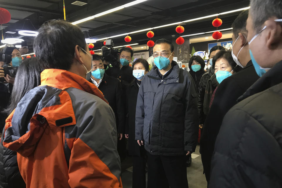 Chinese Premier Li Keqiang, center, talks to shoppers at a supermarket in Wuhan in central China's Hubei province Monday, Jan. 27, 2020. On Monday, China's No. 2 leader, Premier Li Keqiang, visited Wuhan to "guide epidemic prevention work," the Cabinet website said. (Chinatopix Via AP)