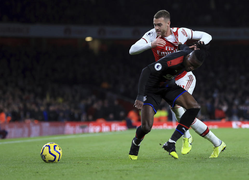 Crystal Palace's Wilfried Zaha, front, duels for the ball with Arsenal's Calum Chambers during the English Premier League soccer match between Arsenal and Crystal Palace at the Emirates stadium in London, Sunday, Oct. 27, 2019. (AP Photo/Leila Coker)